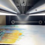 Numérisation d'une œuvre colorée sous la barre lumineuse LED du scanner grand format